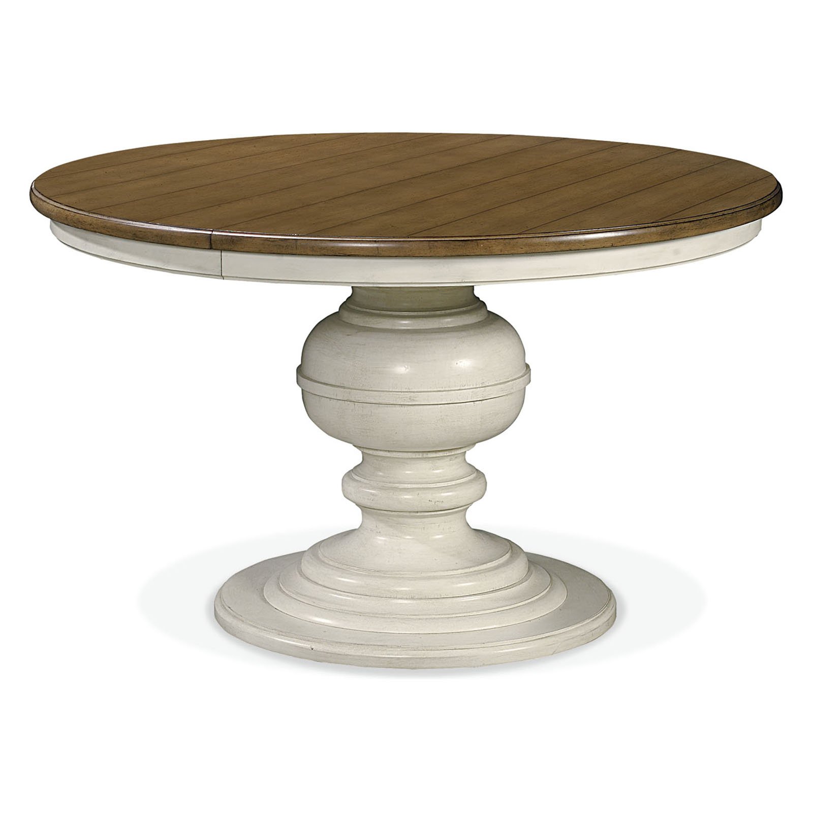Round pedestal dining table with wood top and cream painted base on a plain white background